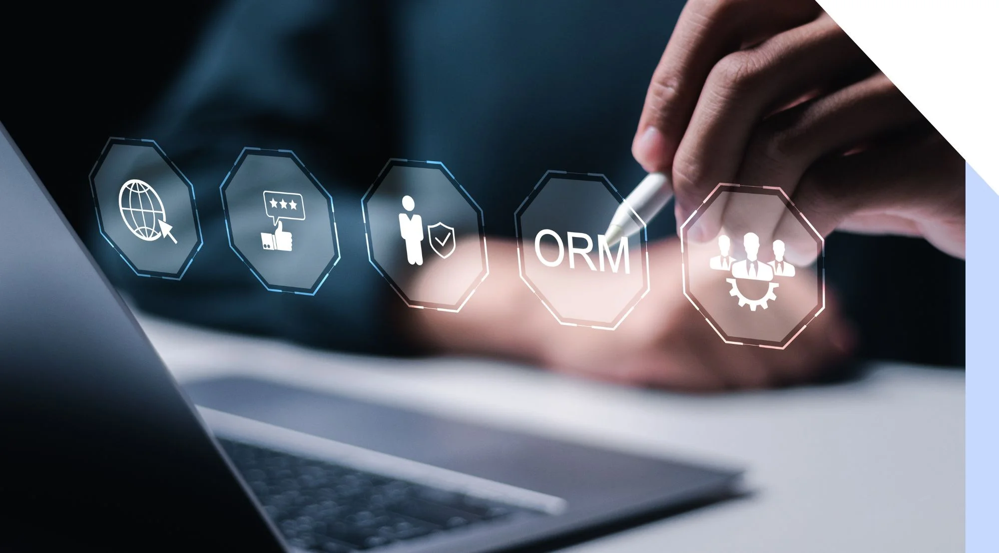 A person using a stylus to interact with digital ORM and marketing icons above a laptop