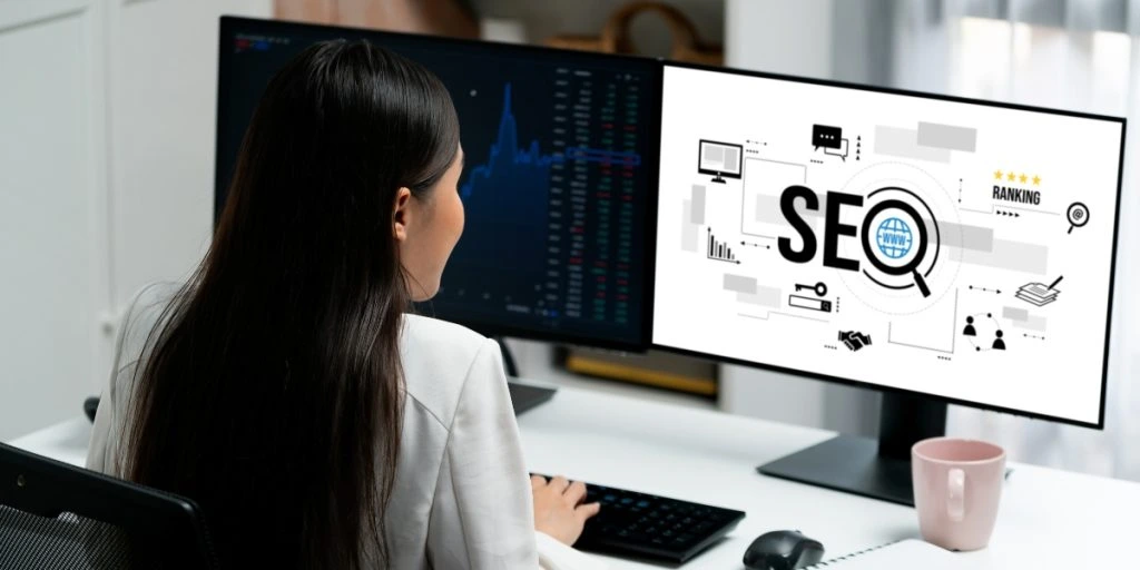 A person working on a computer with SEO graphics on the screen