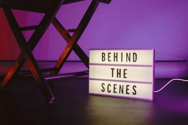 behind the scenes written on a board